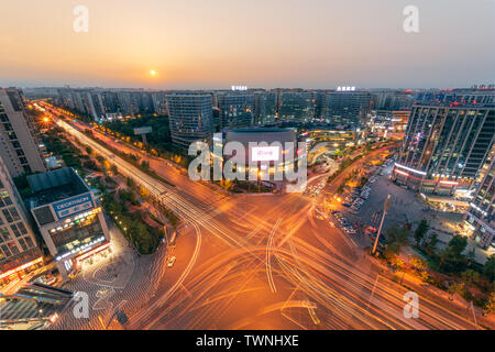 Chengdu, Provinz Sichuan, China - Juni 5, 2019: PangRuiLi commercial Mall und der Kreuzung mit der Skyline der Stadt Luftaufnahme bei Sonnenuntergang Stockfoto