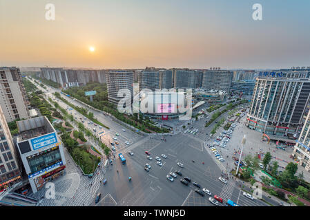 Chengdu, Provinz Sichuan, China - Juni 5, 2019: PangRuiLi commercial Mall und der Kreuzung mit der Skyline der Stadt Luftaufnahme bei Sonnenuntergang Stockfoto