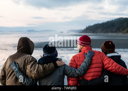 Zwei pensionierte Paare zu Fuß am Strand. Stockfoto