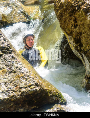 Canyoning - Frau gleiten auf Felsen, Wasserfall Stockfoto