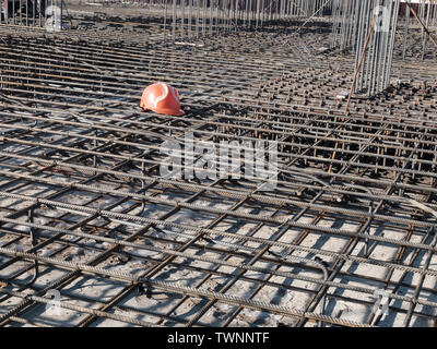 Orange hardhat auf den Stahl Raster von Wohngebäuden Grundlage Verstärkung. Stockfoto