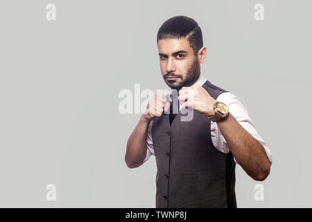 Porträt von Ernst bärtiger Mann im weißen Hemd und Weste mit Boxing Fäuste und Kamera mit aggressiven Gesicht und zum Angriff bereit Stockfoto