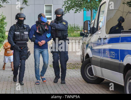 Magdeburg, Deutschland. Juni, 2019 21. Bewaffnete Polizisten ein Mann weg während einer Droge raid nehmen. Am Freitag Abend, das Special Operations Command (SEK) wurde in zwei Objekten eingesetzt. Insgesamt wurden vier Männer zwischen 19 und 35 Jahren festgenommen. Credit: Tom Wunderlich/dpa-Zentralbild/dpa/Alamy leben Nachrichten Stockfoto