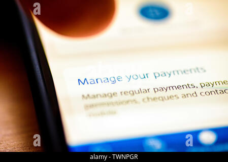 Zahlungen Schaltfläche Verwalten auf dem Smartphone App-closeup mit menschlichen Finger zeigt Stockfoto
