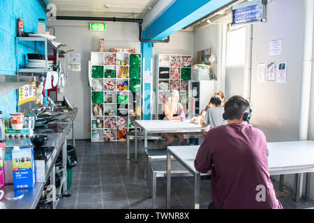 Junge sitzt am Tisch in Hostel Küche Stockfoto