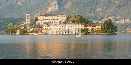 See mit malerischen Insel. Lago d'Orta und die Insel San Giulio bei Sonnenaufgang. Berühmte touristische Ort und großen See in Norditalien Stockfoto