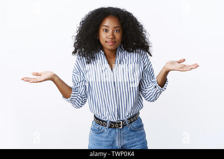 Wer wusste. Clueless zuckend Charmant lächelnd african-american Curly - behaarte Frauen verbreiten Hände seitlich nicht in der Antwort stehen unsicher Apo verwirrt Stockfoto