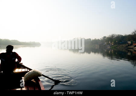 Silhouette der Fährmann Rudern in die yamuna Ganga Fluss in den Morgen. Am frühen Morgen Bootsfahrten auf der Heilige der Heiligen Flüsse Indiens sind eine gemeinsame Stockfoto