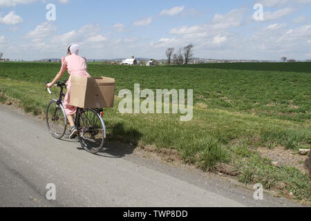 Amish Frau mit dem Fahrrad auf der Landstraße in Lancaster County, PA, USA Stockfoto