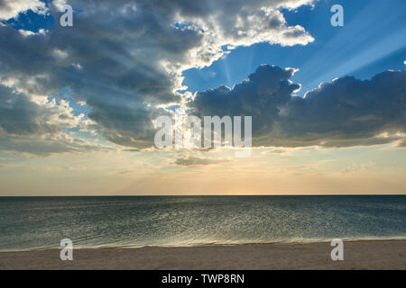 Sonnenuntergang. Sonnenstrahlen durch die Wolken auf dem Meer Stockfoto