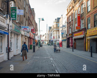 2009, Brick Lane, Spitalfields, ziemlich früh am Morgen Szene gegen den neu errichteten Minarett auf dem alten Hugenottischen Kirche jetzt eine Moschee auf der Suche Stockfoto