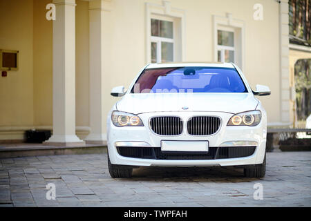 Grodno, Weißrussland, 16. Mai 2013: Moderner Luxus BMW 750Li XDrive auto Vorderansicht auf Stein geparkt gepflasterte Parkplätze in der Nähe von Ancient House horizontal. Stockfoto