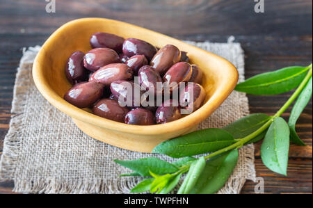 Schüssel von Kalamata Oliven auf der hölzernen Hintergrund Stockfoto