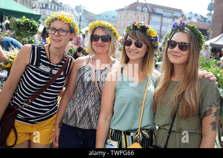 Riga, Lettland. Juni, 2019 21. Die Frauen, die Blume Kronen posieren für Fotos, die während der Midsummer festival Ligo Markt in Riga, Lettland, 21. Juni 2019. Die jährlichen Mittsommer festival Ligo Markt eröffnet hier am Freitag, während die Bauern und Handwerker aus ganz Lettland verkaufen Spezialitäten wie ländlichen Brot, Käse, Tee, Honig, hausgemachte Kuchen und chaplets. Credit: Edijs Palens/Xinhua/Alamy leben Nachrichten Stockfoto