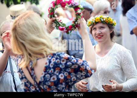 Riga, Lettland. Juni, 2019 21. Die Frauen, die Blume Kronen sind im Hochsommer festival Ligo Markt in Riga, Lettland, 21. Juni 2019 gesehen. Die jährlichen Mittsommer festival Ligo Markt eröffnet hier am Freitag, während die Bauern und Handwerker aus ganz Lettland verkaufen Spezialitäten wie ländlichen Brot, Käse, Tee, Honig, hausgemachte Kuchen und chaplets. Credit: Edijs Palens/Xinhua/Alamy leben Nachrichten Stockfoto