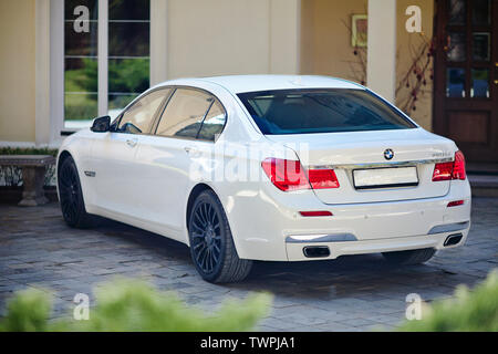 Grodno, Weißrussland, 16. Mai 2013: Moderner Luxus BMW 750Li XDrive Auto drei Viertel obere Ansicht auf Stein geparkt gepflasterte Parkplätze in der Nähe von Ancient House. Stockfoto