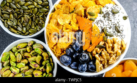 Gesundes Frühstück Schüssel Cornflakes, Joghurt, Aprikosen, Chia Samen, Nüsse und frischen Blaubeeren Stockfoto
