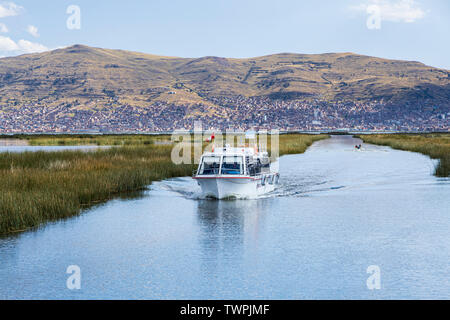 Bootsfahrten durch das Schilf und schwimmende Dörfer von Uros Inseln auf dem Titicacasee, Peru, Südamerika Stockfoto