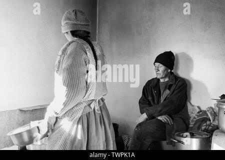 Frau Kochen als ihr Ehemann wathchs in Luquina Chico, Titicacasee, Peru, Südamerika Stockfoto