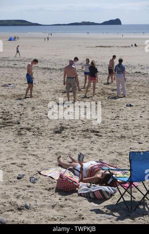 Gower, Swansea, Wales, UK. Am 22. Juni 2019. Wetter: Beachgoers absorbieren die Sonnenschein und wärmere Temperaturen bei llangennith Strand an der Küste Gowers, South Wales. Der Ausblick ist es wärmer als in der letzten Zeit aber immer bewölkt, einzelne Schauer und Gewitter. Credit: Gareth Llewelyn/Alamy leben Nachrichten Stockfoto