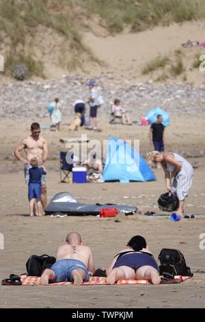 Gower, Swansea, Wales, UK. Am 22. Juni 2019. Wetter: Beachgoers absorbieren die Sonnenschein und wärmere Temperaturen bei llangennith Strand an der Küste Gowers, South Wales. Der Ausblick ist es wärmer als in der letzten Zeit aber immer bewölkt, einzelne Schauer und Gewitter. Credit: Gareth Llewelyn/Alamy leben Nachrichten Stockfoto