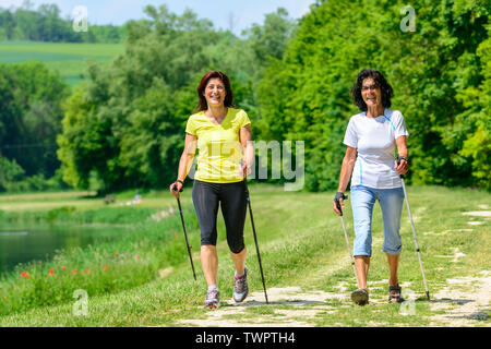 Zwei Frauen, die ein Nordic walking Sitzung in einer wunderschönen Landschaft in Deutschland Stockfoto