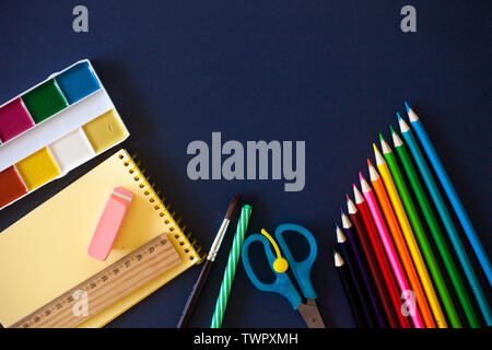 Schulbedarf auf dunkelblauem Hintergrund. Zurück zum Konzept der Schule. Flach, kopieren. Stockfoto