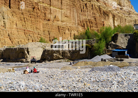 Trockene Flussbett des Kali Gandaki Fluß in Chuksang, Upper Mustang, Nepal. Die lokale Bevölkerung gesehen werden kann brechen Steine in den Weg. Stockfoto