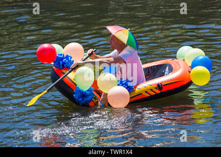 Iford, Dorset, Großbritannien. Am 22. Juni 2019. Perfektes Wetter, warm und sonnig, noch für Dorset Beiboot Tag mit Hunderten von Schlauchboote, Faltboote, Handwerk, Platten bilden eine Flottille Segeln von iford Brücke, den Fluss Stour zu Tuckton Brücke. Die Veranstaltung begann im Jahr 2014 als ein wenig Spaß, aber hat jetzt eine jährliche Veranstaltung Geld für Nächstenliebe und Getter jedes Jahr größer geworden. Mann Spaß im Beiboot mit Ballons und tragende Dach hat. Credit: Carolyn Jenkins/Alamy leben Nachrichten Stockfoto
