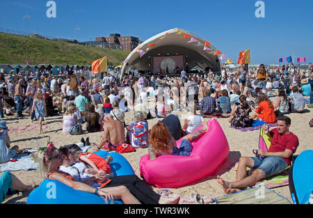 Am 22. Juni 2019. Lowestoft, England, UK. Von Lowestoft First Light Festival, Menschenmassen auf South Beach mit Temperaturen von über 20 Grad mit schönen blauen Himmel zu sammeln. Festival läuft für 24 Stunden non-stop bis 12:00 Uhr am Sonntag. Besucher Blick auf das Stroh Pakefield Mann'. Kunst liebe FlipSide, liefern die Festival in Partnerschaft mit Hemingway Design. Besucher Blick auf das Stroh Pakefield Mann'. Stockfoto