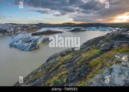 Sonnenuntergang auf Eisberge und Eisschollen im Svinafell Lagune, Nationalpark Skaftafell von Island. Ring Road Sehenswürdigkeiten. Berühmte Touristenattraktion bei Sonnenuntergang. Stockfoto