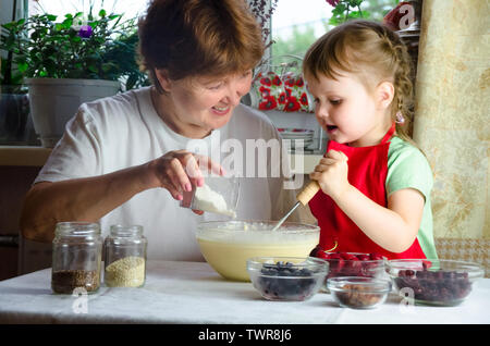 Portrait von Gesichtern, Händen glücklich braunhaarige Oma, Enkelin. Kleinkind Mädchen spielen mit Backen, Teig, Mehl auf Küche. Kind Baby versuchen Studie cookin Stockfoto