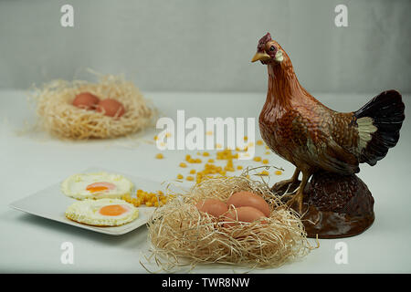 Spiegeleier und frische Eier in Nester von Stroh und ein schönes Porzellan Henne Stockfoto