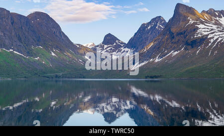 Einen schönen Berg Reflexion ist auf dem tiefblauen Wasser von einem Fjord, direkt an der National Scenic Route auf der arktischen Insel Senja, Norwegen erfasst Stockfoto