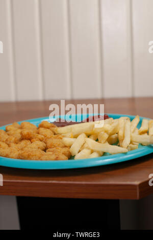 Hausgemachtes popcorn Garnelen, Pommes frites und Ketchup auf einem blauen Platte Stockfoto