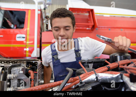 Gerne männliche Feuerwehrmann zur Festsetzung der Lkw in einem Fire Station Stockfoto
