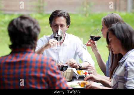 Freunde trinken Rotwein im Freien Abendessen Stockfoto