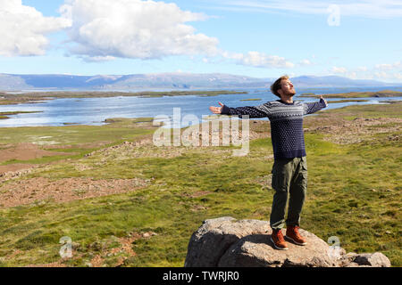 Freiheit der Mensch in der Natur auf Island zufrieden mit Waffen mit kostenfreiem Glück im wunderschönen isländischen Landschaft. Männliche Wanderer entspannen in der Natur. Stockfoto