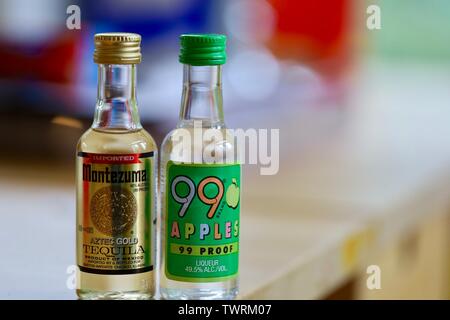 Miniatur Flaschen Aztec Gold und Äpfel 99 Nachweis Tequila auf hölzernen Tisch Stockfoto