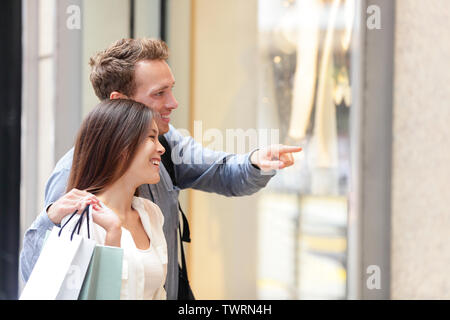 Menschen einkaufen in Hong Kong Central. Paar an Schaufenstern holding Einkaufstaschen suchen. Urban Mixed Race Asiatische chinesische Frau Shopper und kaukasischen Mann lächelnd glückliches Leben in der Stadt. Stockfoto