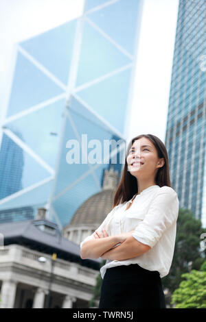 Asian Business Frau zuversichtlich Outdoor in Hongkong steht stolz in der Klage, im Geschäftsviertel bewaffnet. Junge gemischte Rasse chinesische Asiatische/Kaukasisch weiblichen professionellen im Zentrum von Hong Kong. Stockfoto