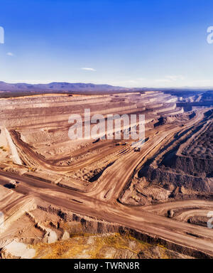Tiefe multi-layer aufgeschnitten Mine auszugraben Steinkohle für das Brennen mit Liddell Power Station im Upper Hunter Valley von Australien. Schwere Lkw, roh Stockfoto