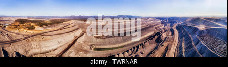 Open Cut Black Coal Mine in New England teil der Hunter Valley, Australien, im erhöhten Antenne Panorama über tiefe Baugrube und schwere Maschinen unten Stockfoto