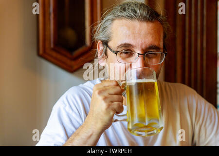 Zugeschnittenes Bild von stattlicher Mann trinkt Bier in der Bar Stockfoto