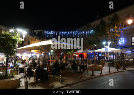 Rivlin Strasse gesäumt mit Cafés und Restaurants mit Menschen sitzen an Tischen draußen auf Nahalat Shiva ein ehemaliger Hof Nachbarschaft, die war das dritte Viertel außerhalb der Altstadt von Jerusalem in den 1860er Jahren gebaut. Heute ist es eine überfüllte Fußgängerzone mit Straßencafés gesäumt. West Jerusalem Israel Stockfoto