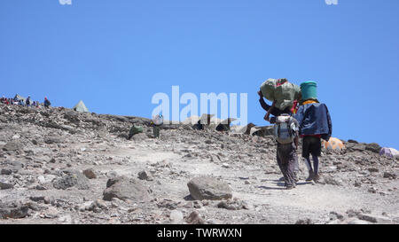 Mount Kilimanjaro/Tansania: 5. Januar 2016: Torhüter tragen Ausrüstung und Material zum Barafu Camp auf dem Berg Kiliimanjaro während einer Klettern expedition Stockfoto