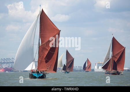 Thames Estuary, Vereinigtes Königreich. 22. Juni, 2019. Lastkähne Rennen auf der Themse, nähert sich moderne cargo Einrichtungen im London Gateway. Historische segeln Lastkähne haben an die 88. Ausgabe des Thames Sailing Barge Match in der Themsemündung, beendete bei Gravesend, Kent. Die Flotte der 10 Lastkähne für das erste Mal eine brandneue Sailing Barge Blue Mermaid, Cargo und Auszubildende, die Gewinnen meer Zeit zum Erlernen der traditionellen Seemannschaft Kenntnisse zu tragen. Rob Powell/Alamy leben Nachrichten Stockfoto