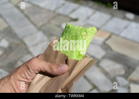 Grüne Fladenbrot, shaurma, shaverma, Kebab, Döner Shawarma in männlicher Hand Nahaufnahme Stockfoto