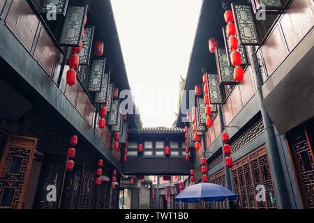 Alte chinesische Gasse mit roten Laternen und Holzfenster in traditioneller Markt in Daocheng Stockfoto