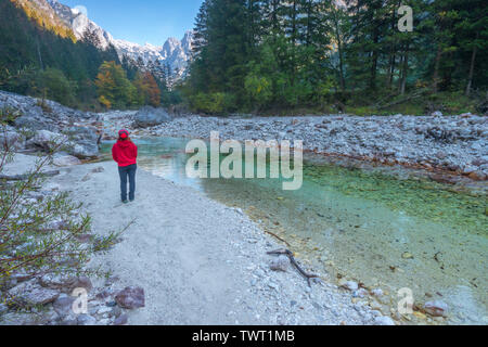 Einsame weibliche Wanderer die Natur starrte. Niedriger Fluss Soca fließt in die slowenischen Alpen und Wälder. Gebirge und die Farben des Herbstes, Laub im Wald. Stockfoto